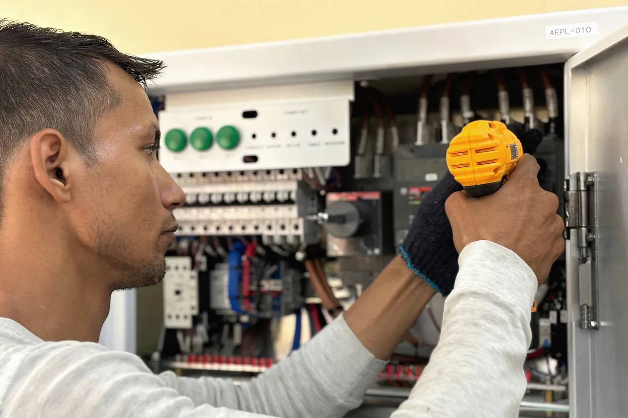 Symbolbild: Ein Elektriker arbeitet an einem Verteilerschrank